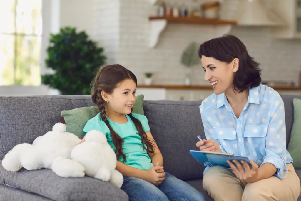 Female counsellor or teacher with female child sharing a pleasant moment together